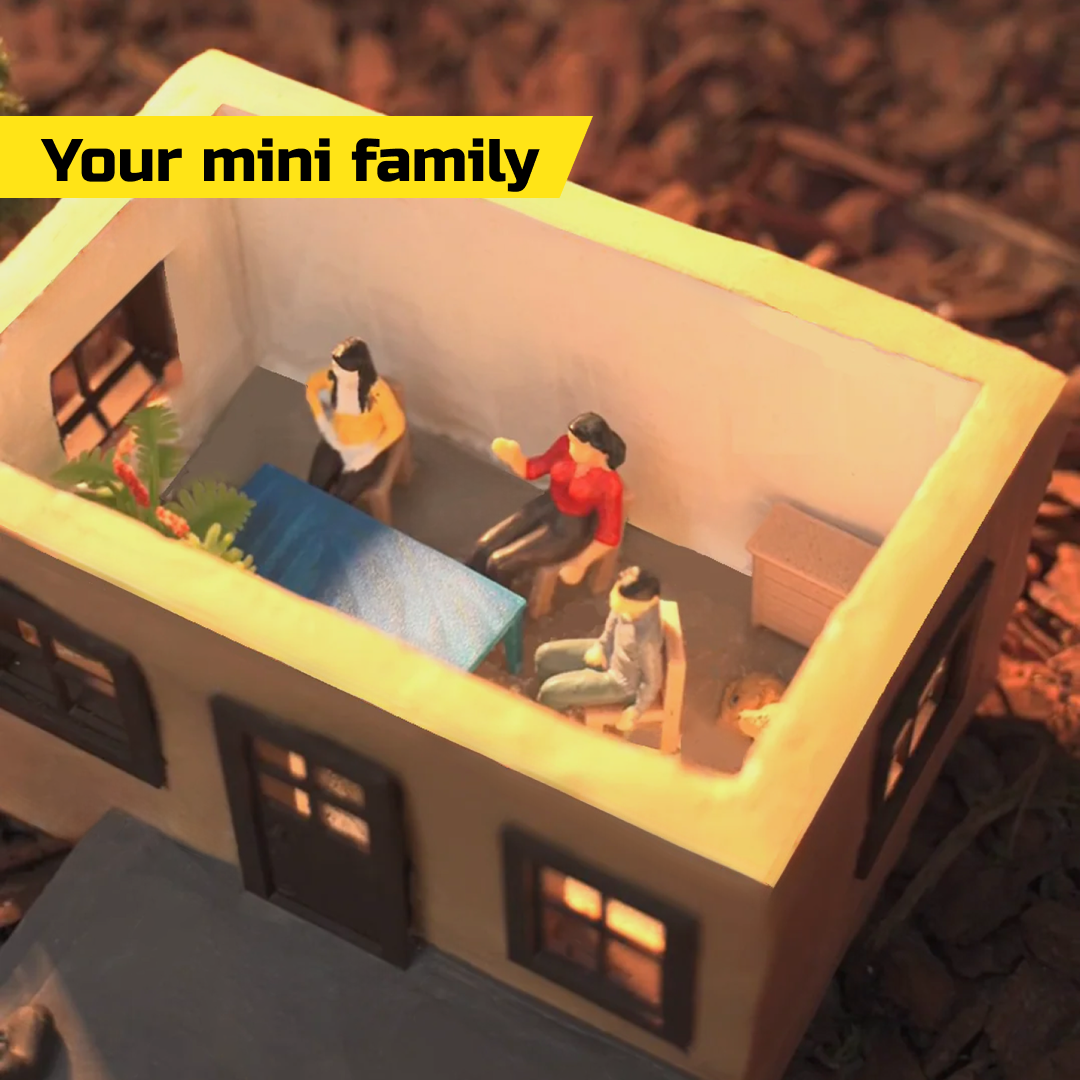 Miniature concrete house with small family figures inside