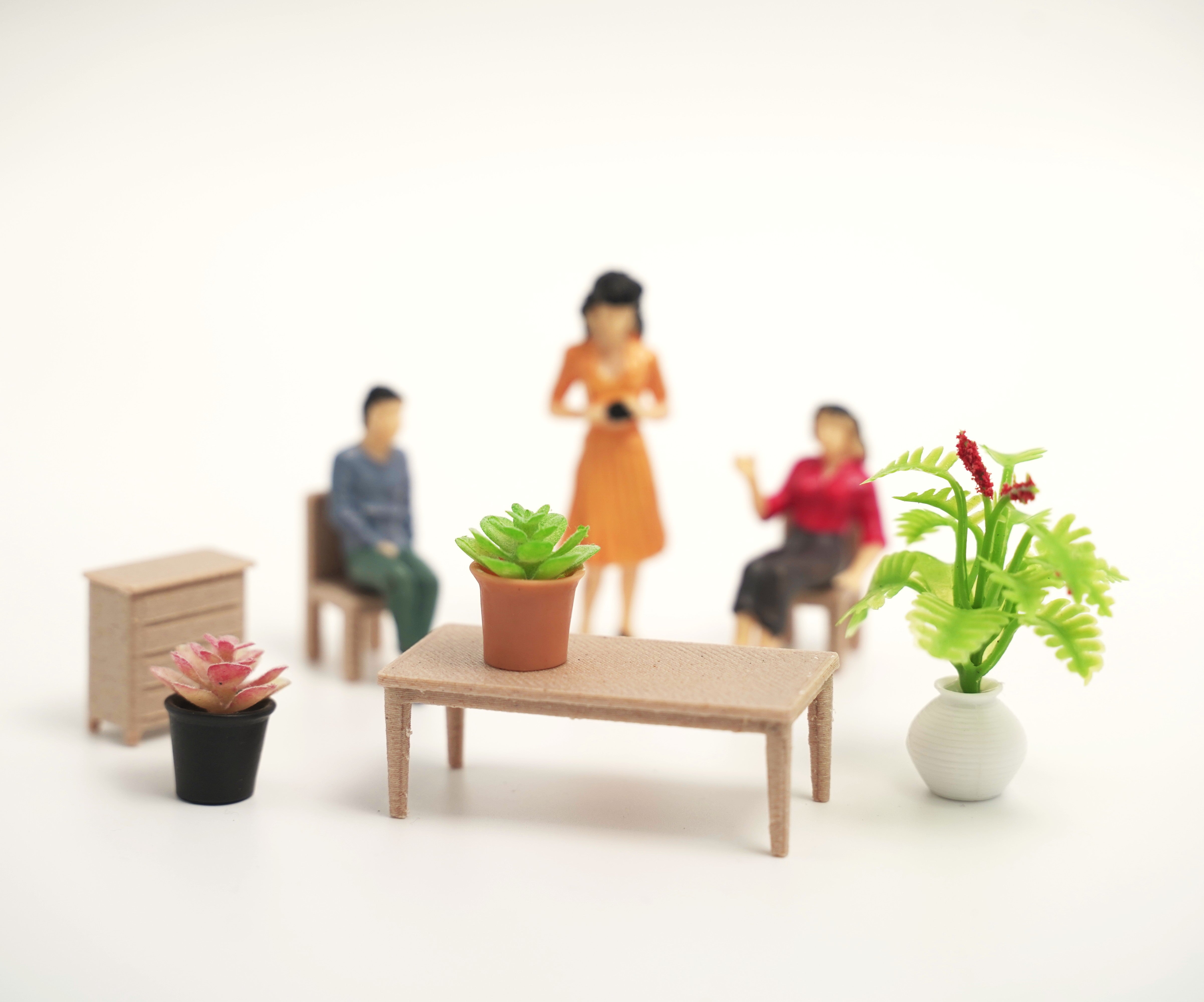Miniature figures of people and plants in a room setting